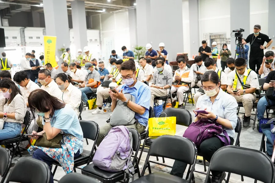 圖片說明：與會者填寫專題演講現場調查問卷中。